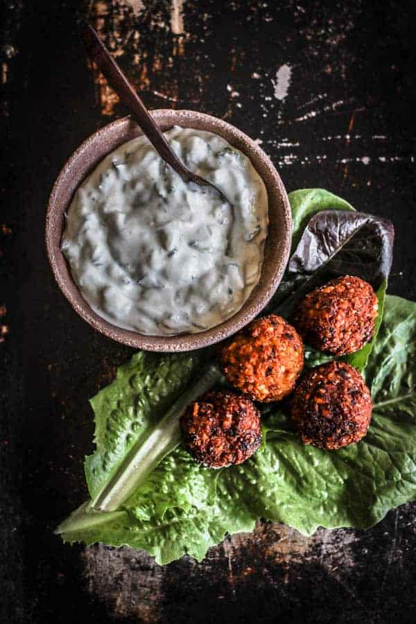 A bowl of Homemade Tzatziki Dip next to sweet potato falafel lettuce cups