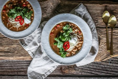 2 bowls of Chickpea and White Bean Chili on a wooden table top