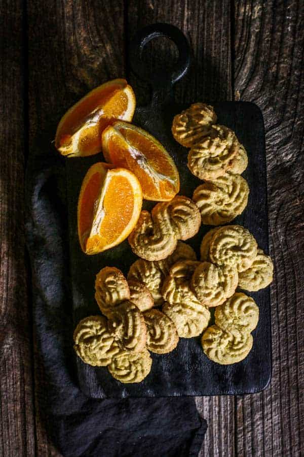 Gluten Free Italian Polenta Cookies on a serving board with wedges of citrus.