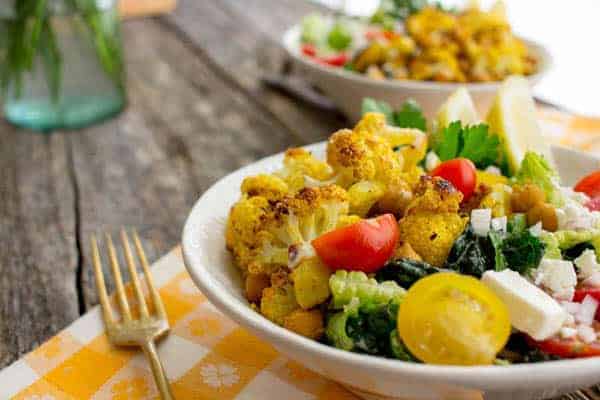 A bowl of Roasted Chickpea & Cauliflower Shawarma with roasted veggies and cool salad greens