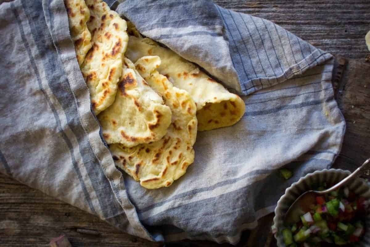 Gluten Free Roasted Garlic Naan in a basket lined with a linen cloth