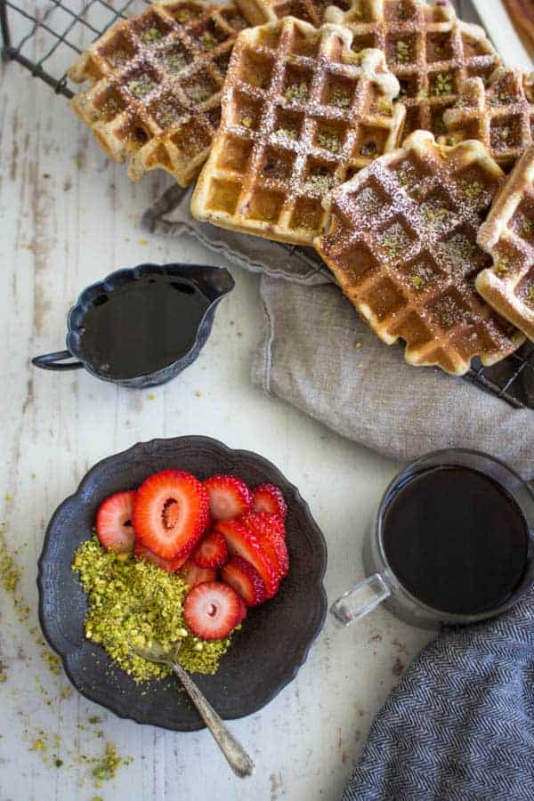 Decadent Strawberry and Pistachio Waffles dusted with powdered sugar. || @thismessisours