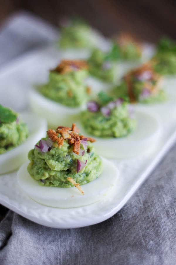 deviled eggs filled with guacamole filling and topped with crispy chips