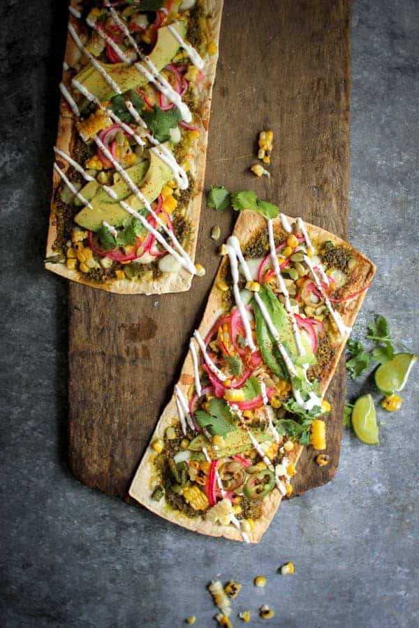 Grilled Mexican Street Corn Pizza recipe || Cilantro pistachio pesto + grilled corn + pickled red onions + avocado makes for one heck of a street corn inspired pizza! || @thismessisours @flatout #spon #flatoutlove