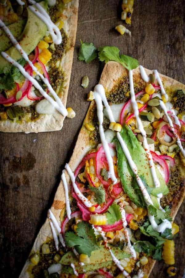 Grilled Mexican Street Corn Pizza recipe || Cilantro pistachio pesto + grilled corn + pickled red onions + avocado + cotija cheese makes for one heck of a street corn inspired pizza! || @thismessisours @flatout #spon #flatoutlove