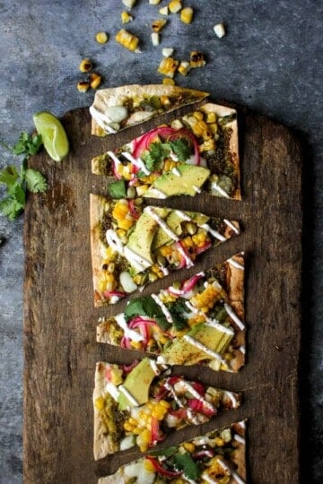 Grilled Mexican Street Corn Pizzas recipe || Cilantro pistachio pesto + grilled corn + pickled red onions + avocado makes for one heck of a street corn inspired pizza! || @thismessisours @flatout #spon