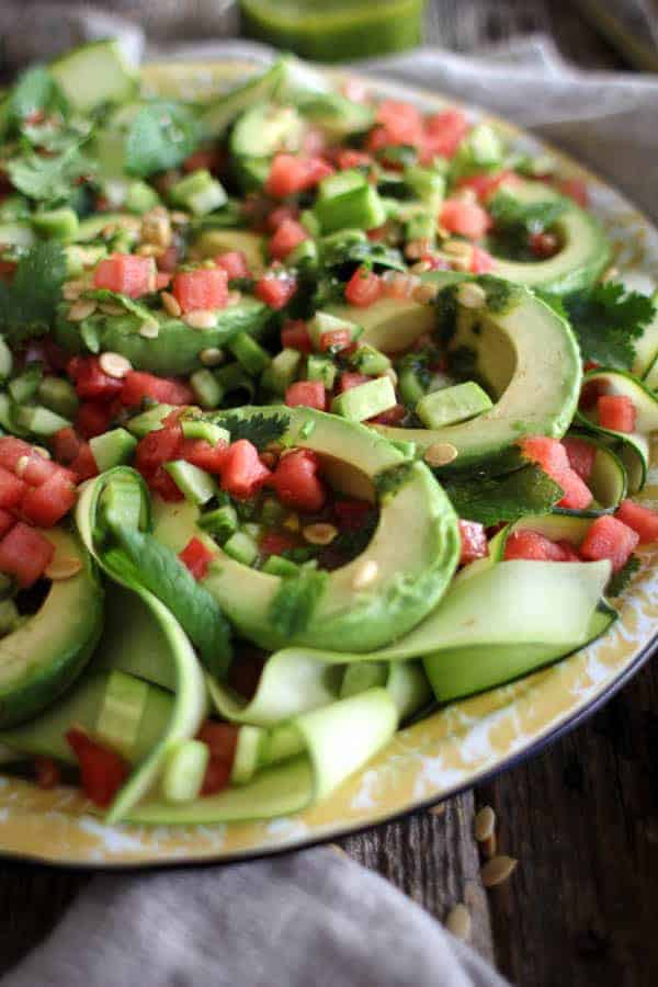 Avocado Avenger Salad recipe || This dreamy summer salad is from @theblendergirl 's latest cookbook The Perfect Blend! Gorgeous avocados over a bed of zucchini ribbons filled with chimichurri then sprinkled with watermelon, tomato, and toasted watermelon seeds. Summer perfection! || @thismessisours #glutenfree #vegan