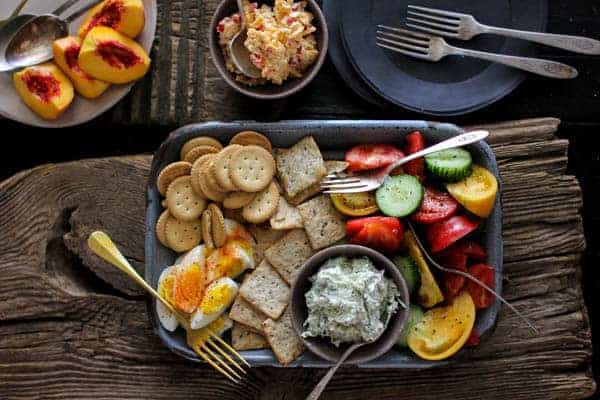 Southern Picnic Platter recipe || This picnic platter transports me back to summers growing up in the south. Homemade pimento cheese, benedictine spread, a juicy heirloom tomato and cucumber salad, fresh peaches, spice dusted hard boiled eggs, and a variety of crackers! My grandmother would have been proud of this one! || @thismessisours