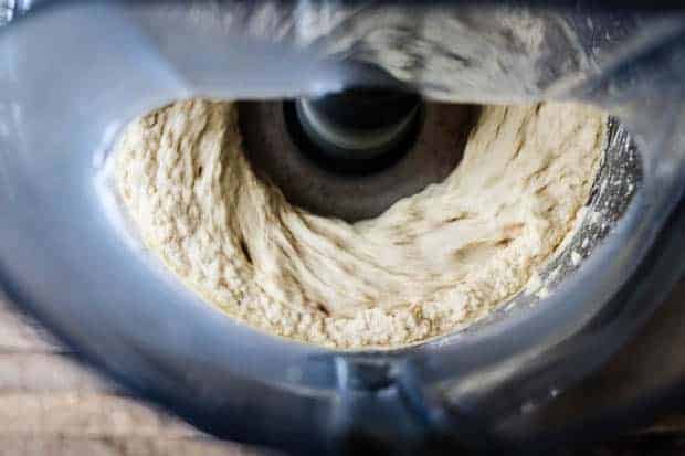 view inside a food processor as it is running, blending hummus