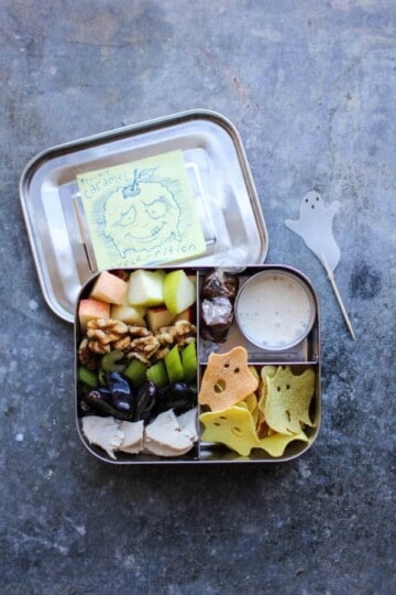 All the elements of a waldorf salad deconstructed and arranged in a bento box with dressing on the side for easy dipping!