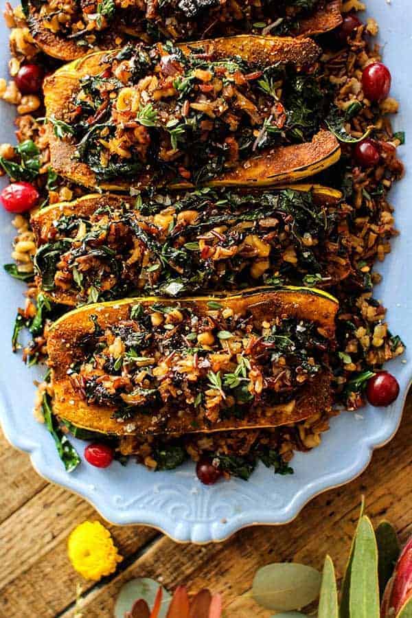 Exotic Rice Stuffed Delicata Squash with Curried Cashew Cream recipe || These curry spiced delicata squash are filled to the brim with an exotic rice blend loaded with onion, garlic, walnuts, kale, and dried bing cherries. This dish is the perfect plant based main dish for your holiday table! || @thismessisours @nutsdotcom