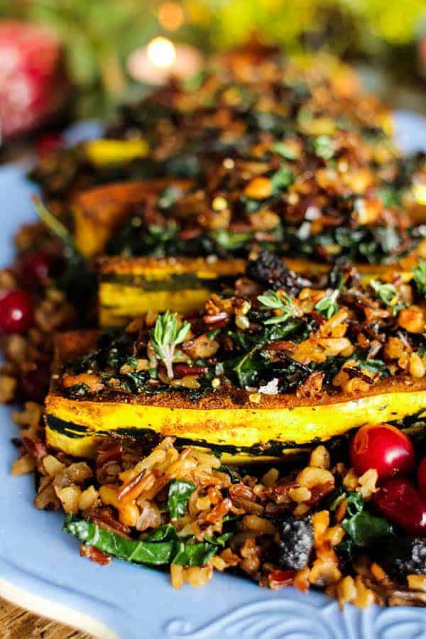 Exotic Rice Stuffed Delicata Squash with Curried Cashew Cream recipe || These curry spiced delicata squash are filled to the brim with an exotic rice blend loaded with onion, garlic, walnuts, kale, and dried bing cherries. This dish is the perfect plant based main dish for your holiday table! || @thismessisours @nutsdotcom