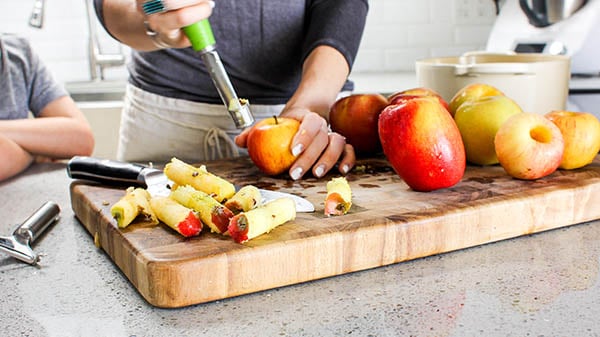 A woman peeling and spring apples for Instant pot applesauce