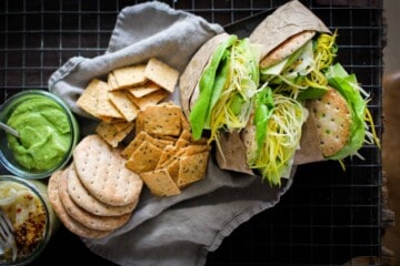 tray of green goddess sandwiches with crackers, sandwich spread, pickled fennel