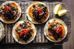 baked tostada with black-eyed pea hummus, roasted sweet potato, and jammy collard greens