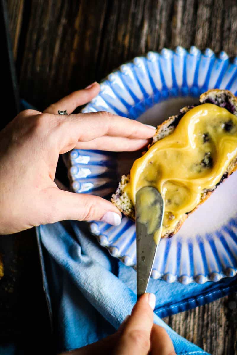 a slice of gluten free blueberry quick bread slathered with spreadable blueberry honey