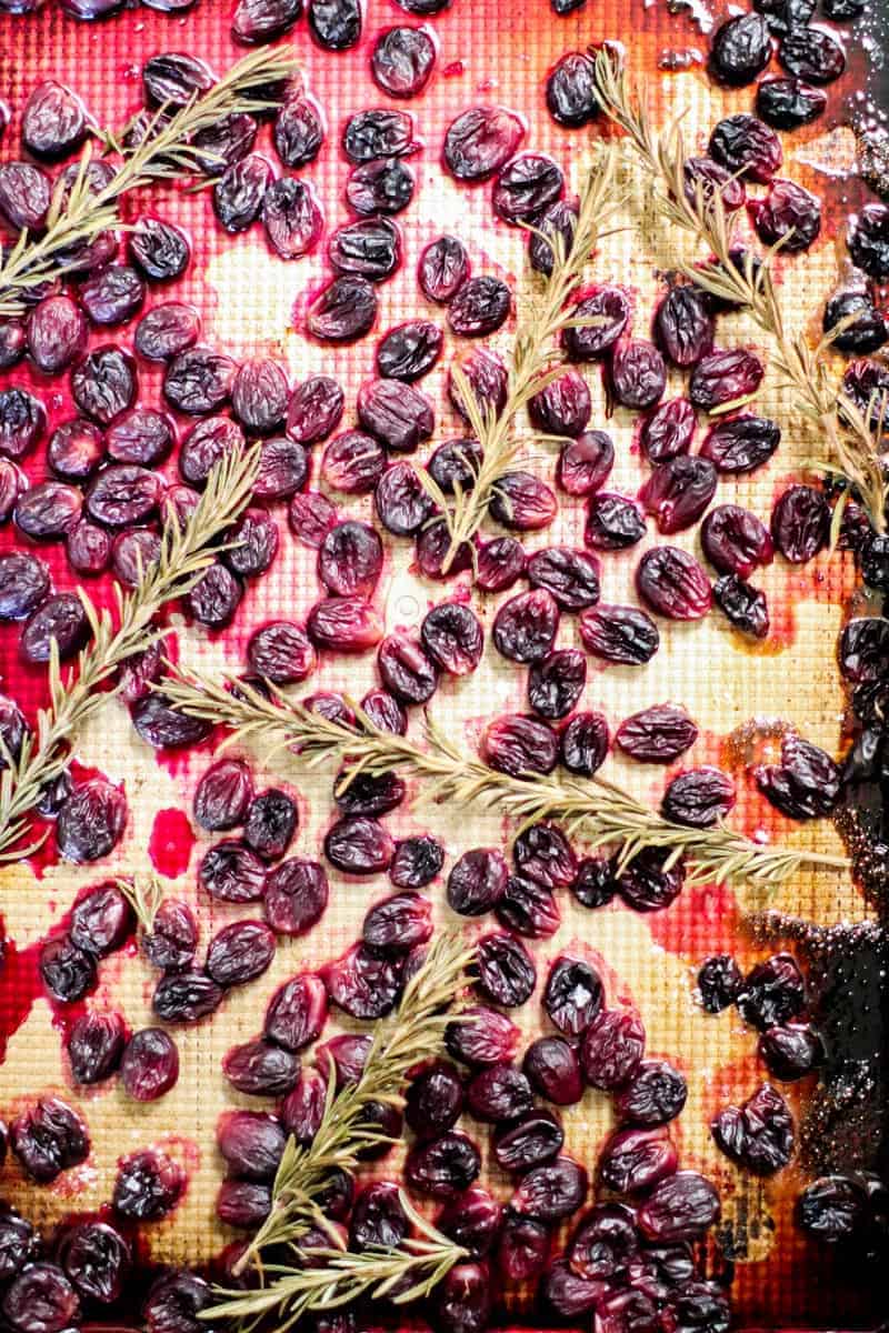 roasted grapes and rosemary on a sheet pan