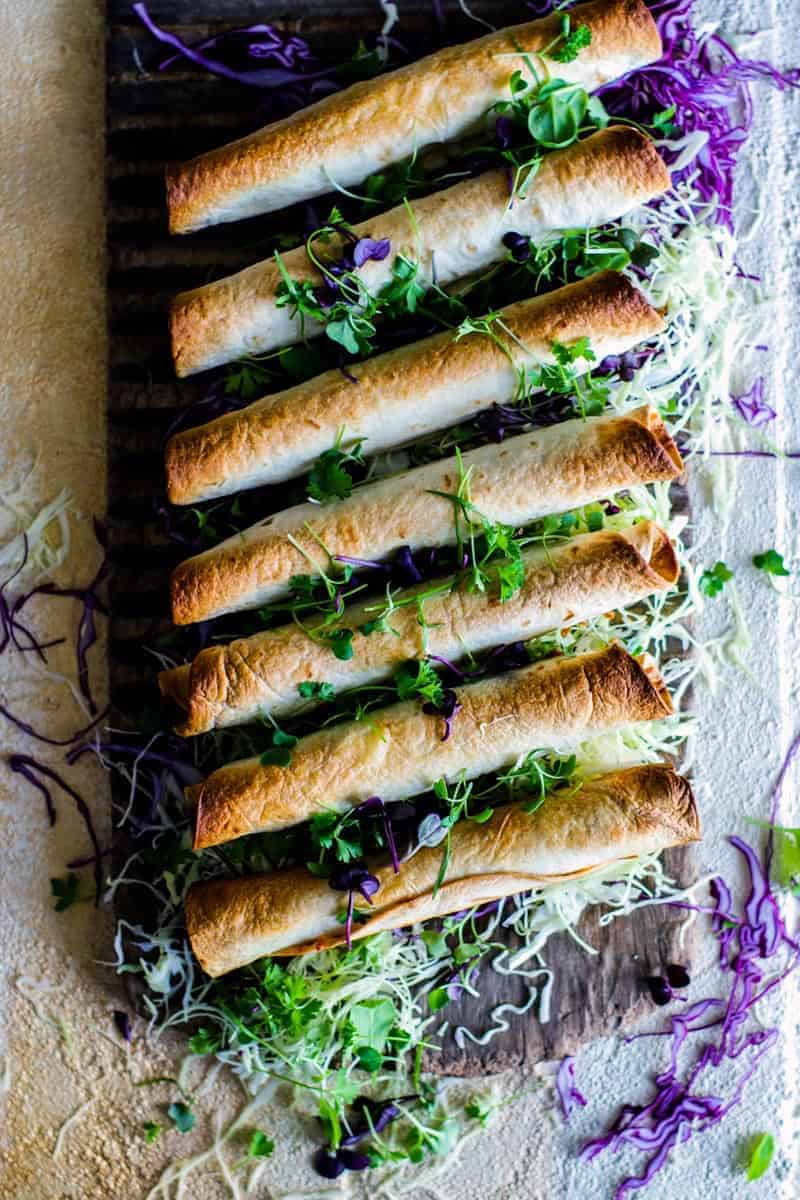 Baked Vegetarian Chili Cheeseburger Taquito s on a bed of shredded cabbage