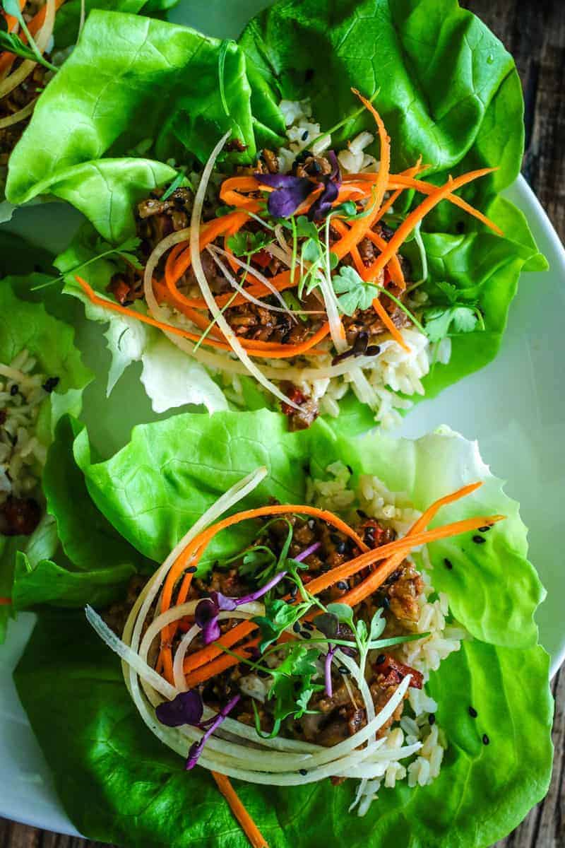 lettuce cups with brown rice, hoisin mushroom filling, shredded carrots, micro greens, and sesame seeds.