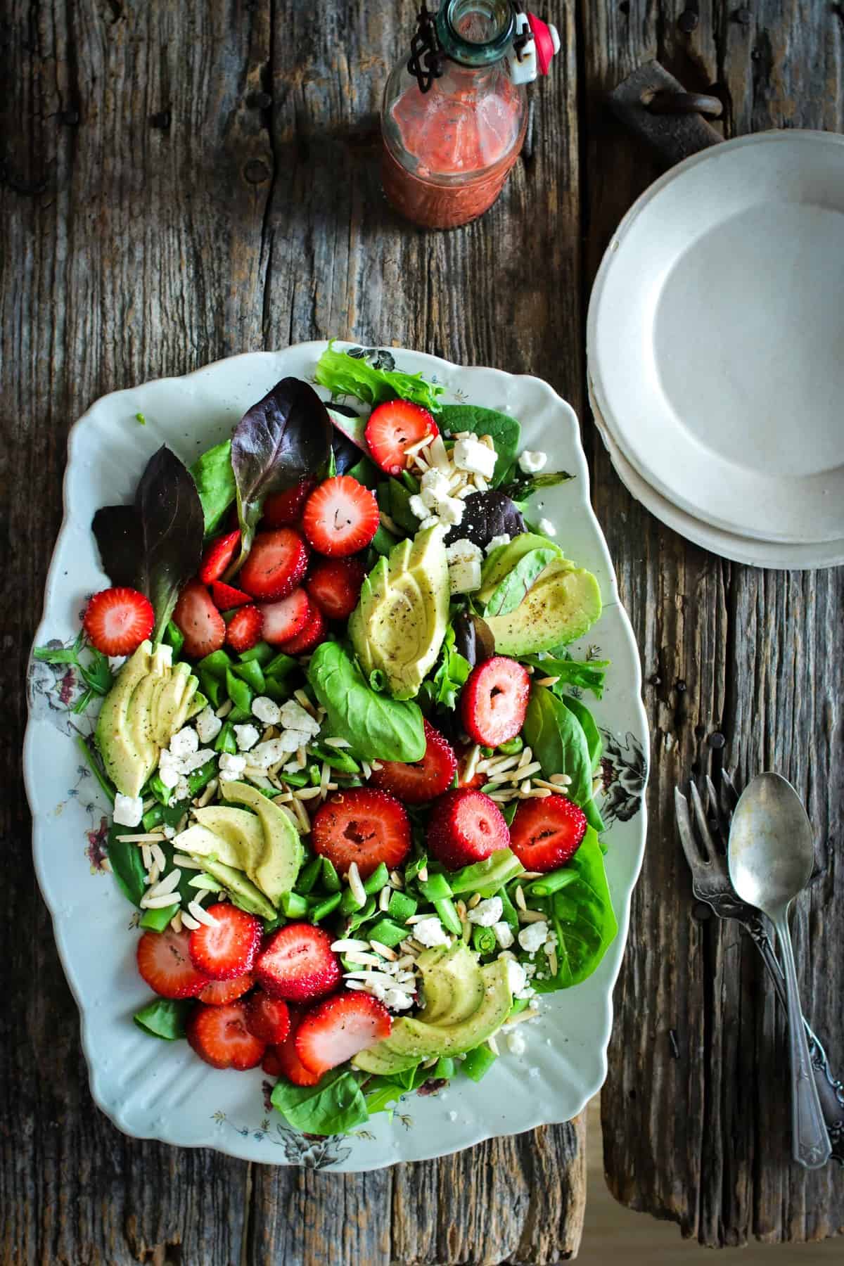 Salad of baby greens, sliced strawberries, avocado, snap peas, toasted almonds, and feta with a strawberry poppyseed dressing.