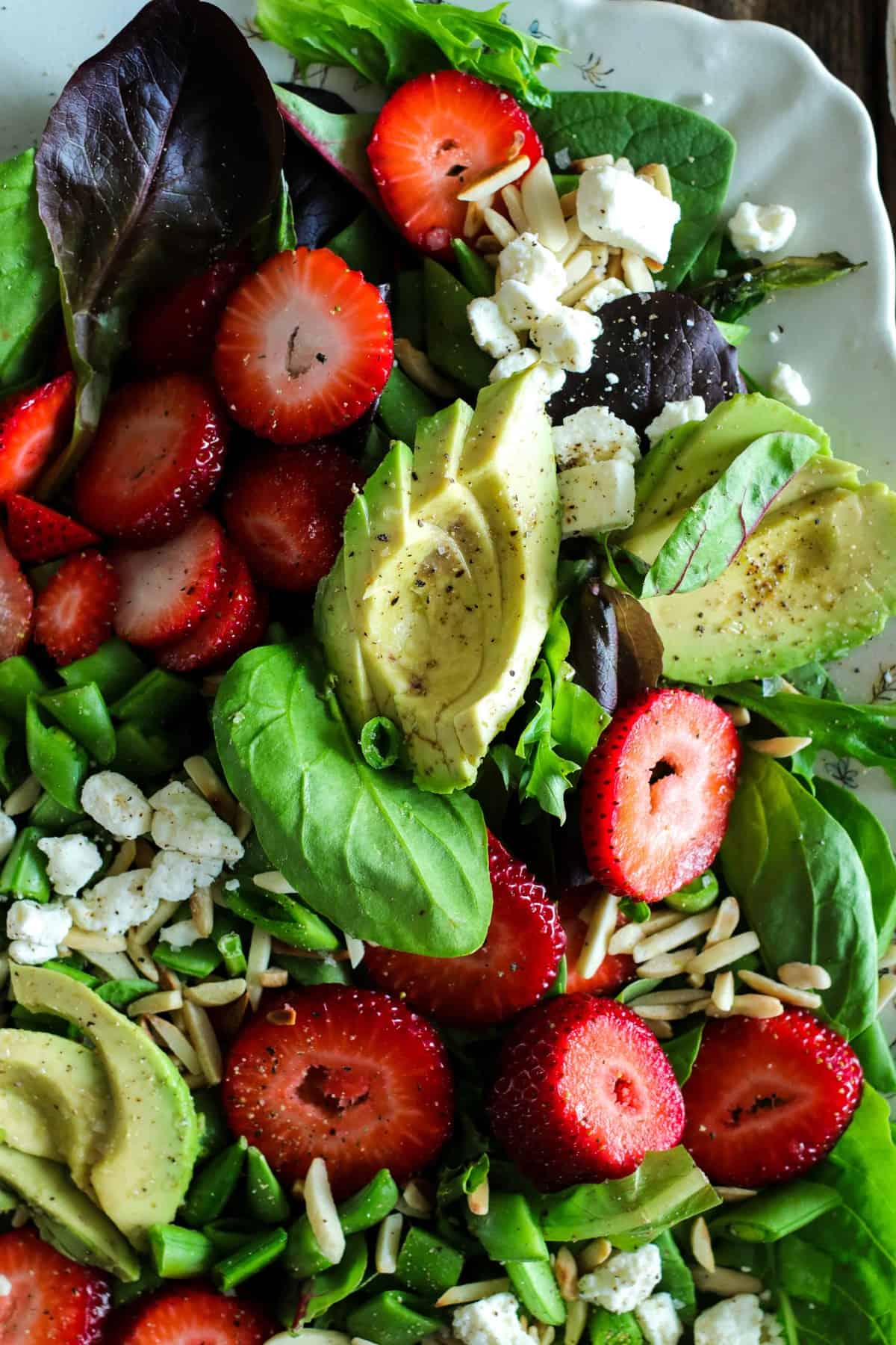 Salad of baby greens, sliced strawberries, avocado, snap peas, toasted almonds, and feta with a strawberry poppyseed dressing.