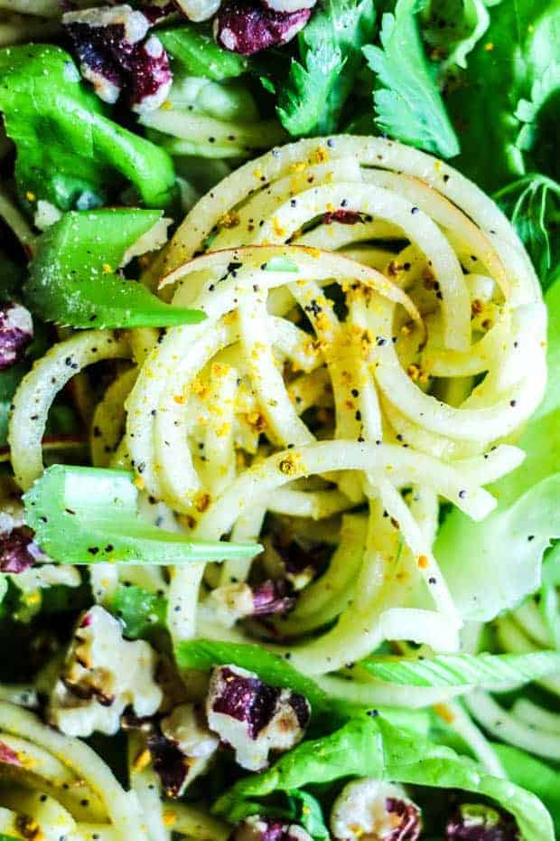 spiralized apple "noodles" tossed in a poppyseed vinaigrette then served on a bed of greens with toasted walnuts, sliced celery, and a sprinkle of yellow bee pollen.