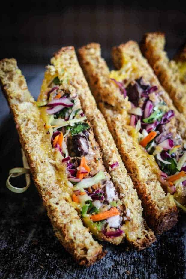 Close up of 2 halves of a vegetarian patty melt with a colorful slaw in the middle 