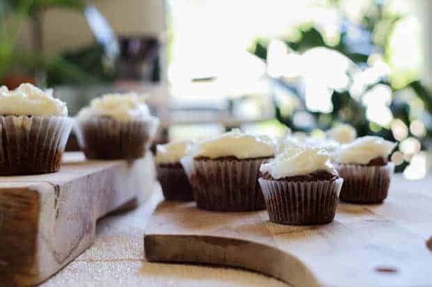 A table full of iced Gluten Free Carrot Cake Muffins 