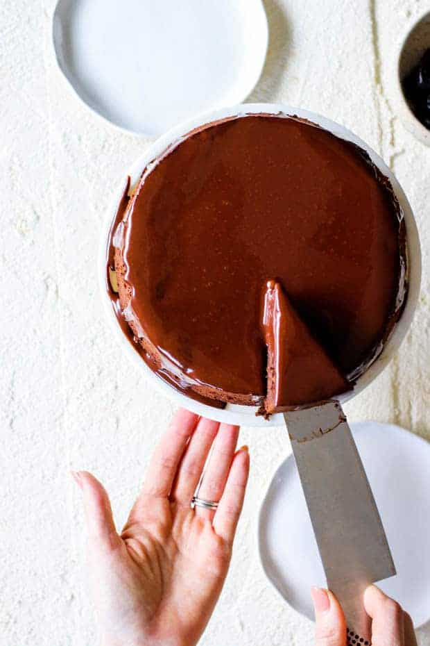 Chocolate Covered Prune Fudge Cake being sliced into with a cake knife