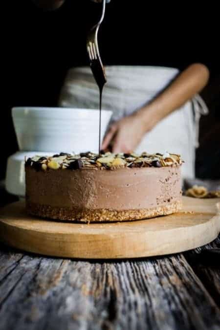 A woman drizzling chocolate over an icebox cake