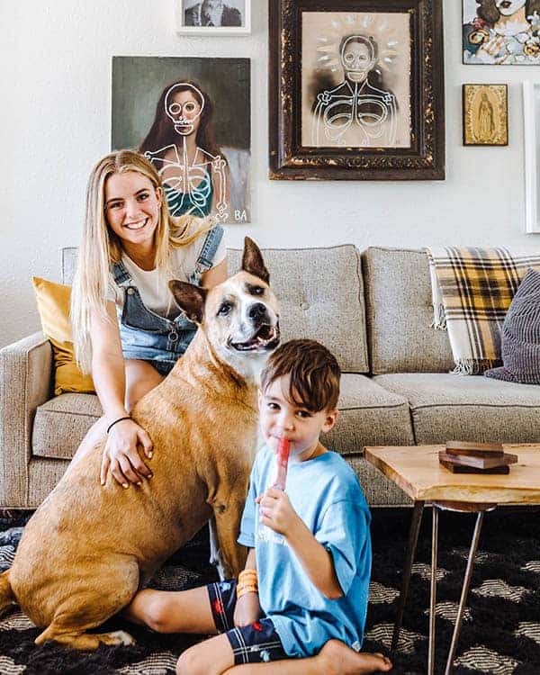 A dog and two children sitting on a couch.