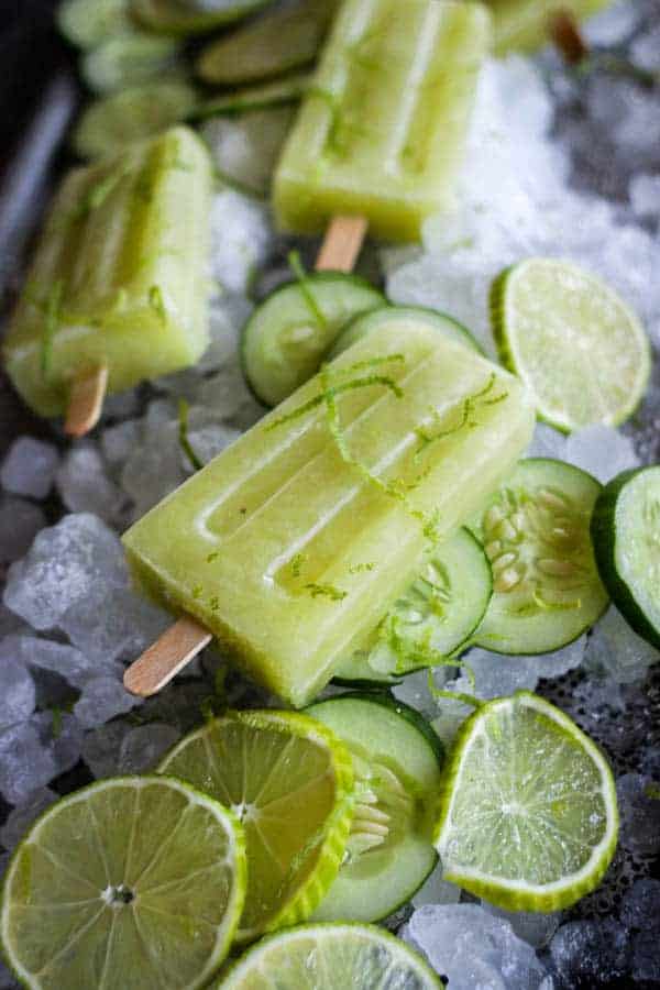 Cucumber Limeade Popsicles, lime wheels, and cucumber wheels on a platter of shaved ice