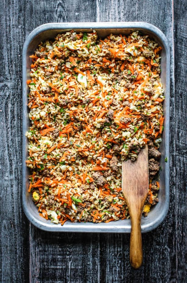 A big pan of homemade dog food that has brown rice, ground beef, chopped hard boiled eggs, and parsley all mixed together