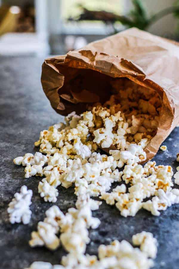 popcorn spilling out of a brown paper bag onto a table