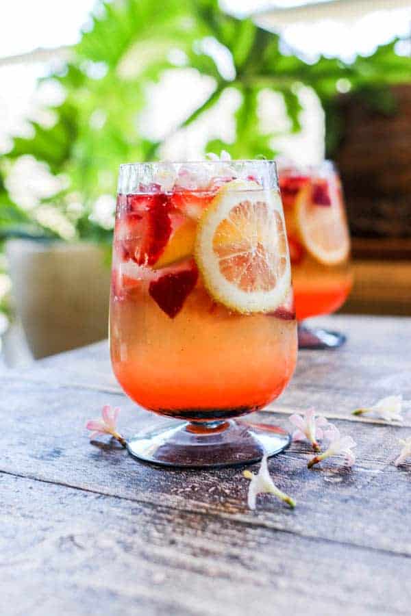 A Strawberry Lemon Smash Cocktail with fresh strawberries and lemon wheels