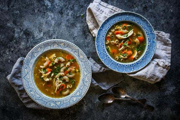 2 bowls of homemade chicken noodle soup made with The Easiest DIY Rotisserie Chicken Broth