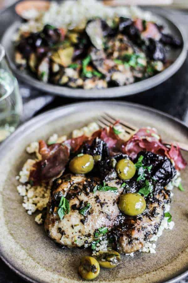 A plate of Quick and Easy Sheet Pan Chicken Marbella over millet with crispy prosciutto