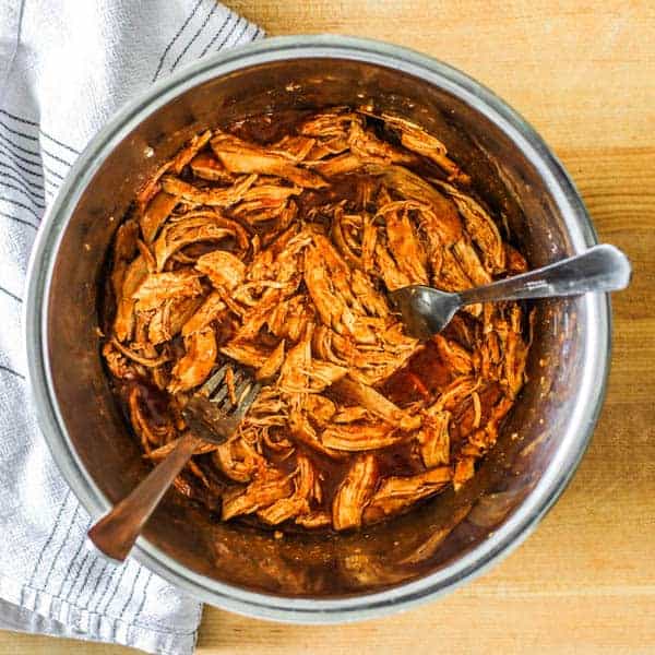 Shredded Mexican Chicken in the Instant Pot after being shredded and tossed with red enchilada sauce
