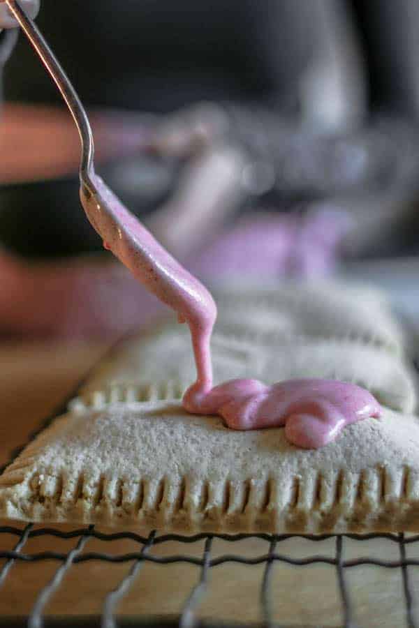 homemade pop tarts being drizzled with pink icing