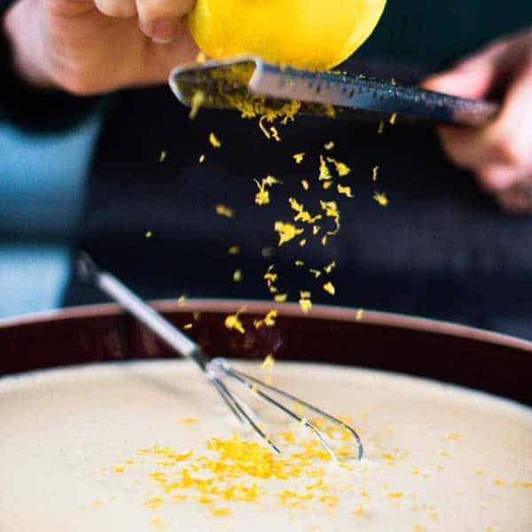 A lemon being zested over the batter for the recipe for french toast