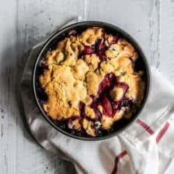 A pan of black and blueberry cobbler fresh from the oven.