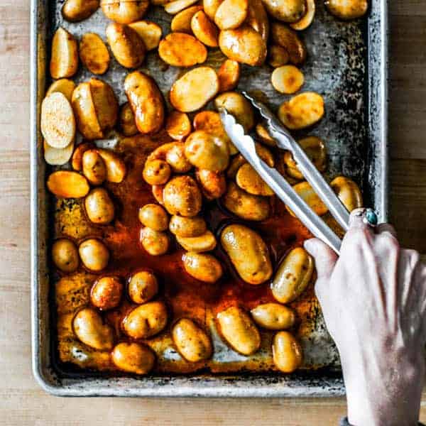 Potato halves being arranged cut side down on a sheet pan