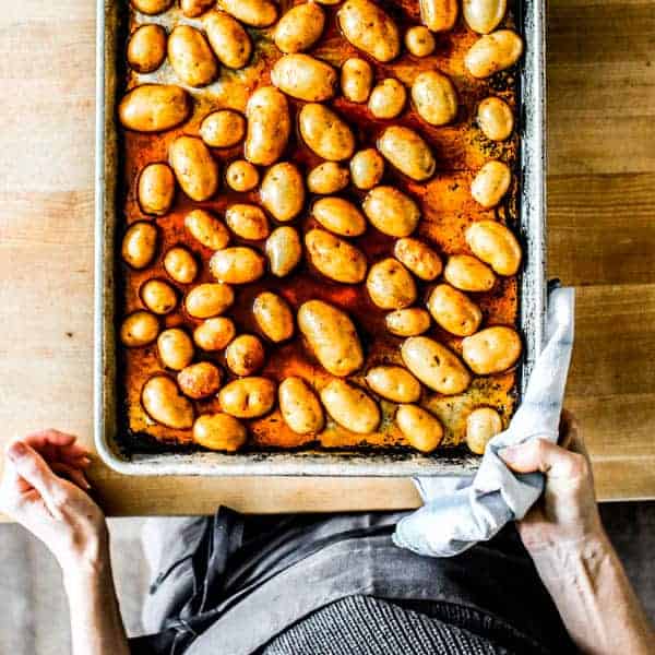 Potato halves cut side down on a sheet pan