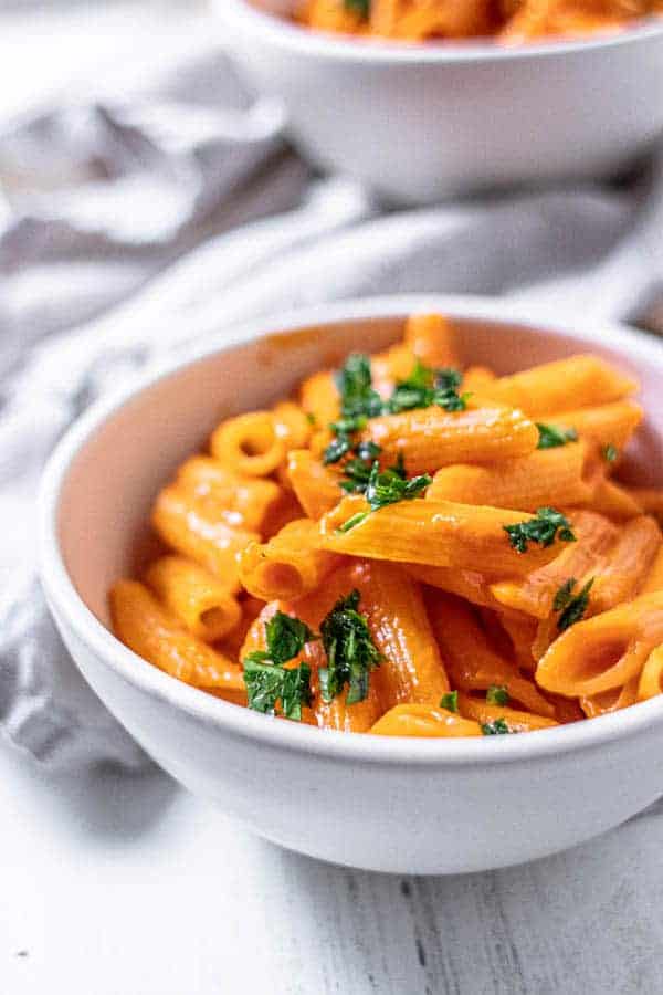 A bowl of penne pasta topped with our homemade marinara sauce recipe and chopped fresh parsley