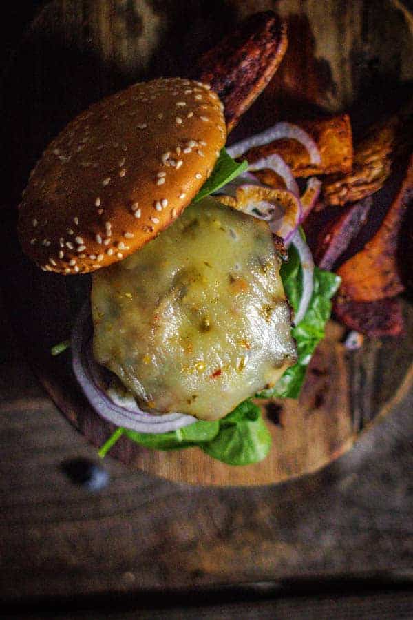 Our juicer turkey burger recipe covered in a slice of melted jalapeño jack cheese net to a side of oven roasted potatoes.