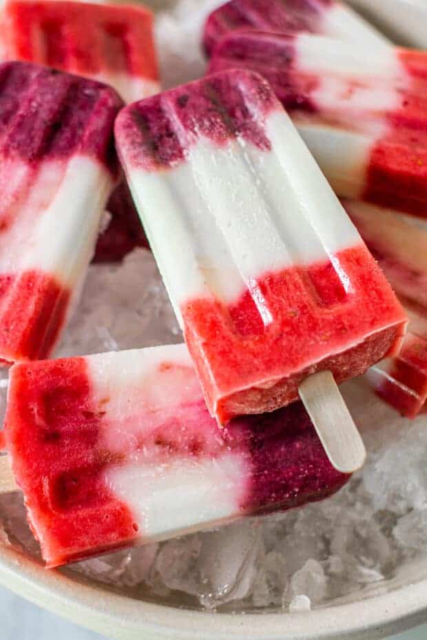 Red, white, and blue popsicles on a platter of ice. 