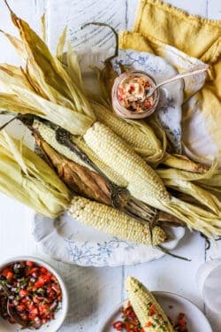 How to Cook Corn on the Cob in the Oven in the husk. The corn is served on a platter.