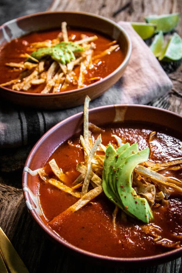 A bowl of instant pot tortilla soup with avocado and tortilla strips