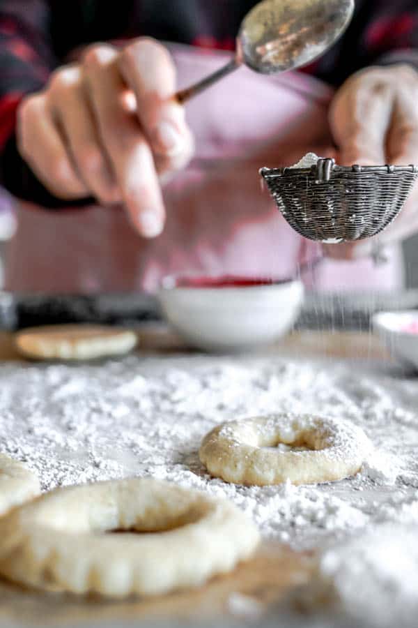 A woman decortaing gluten free sugar cookie 