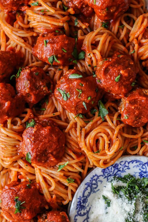 Up close of sheet pan meatballs over spaghetti. 